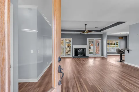a view of a livingroom with wooden floor and a fireplace