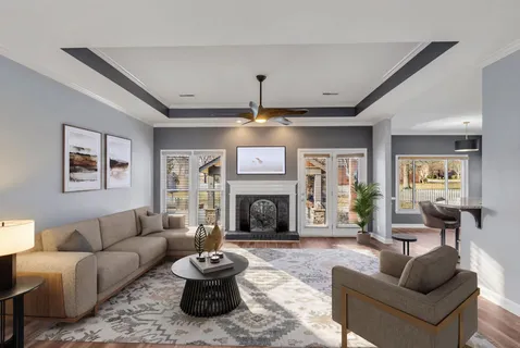 a living room with furniture a fireplace and a chandelier