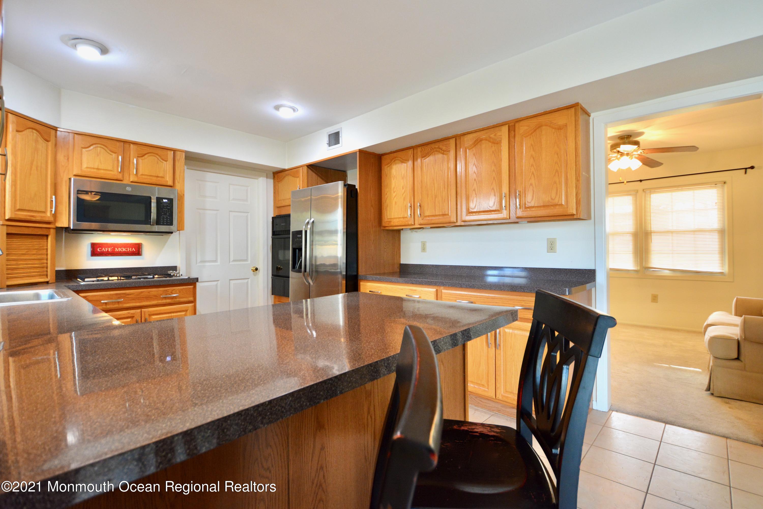 584 Lloyd Road Aberdeen, NJ 07747 - Photo 3 of 5 a view of a kitchen with kitchen island granite countertop a large window and stainless steel appliances
