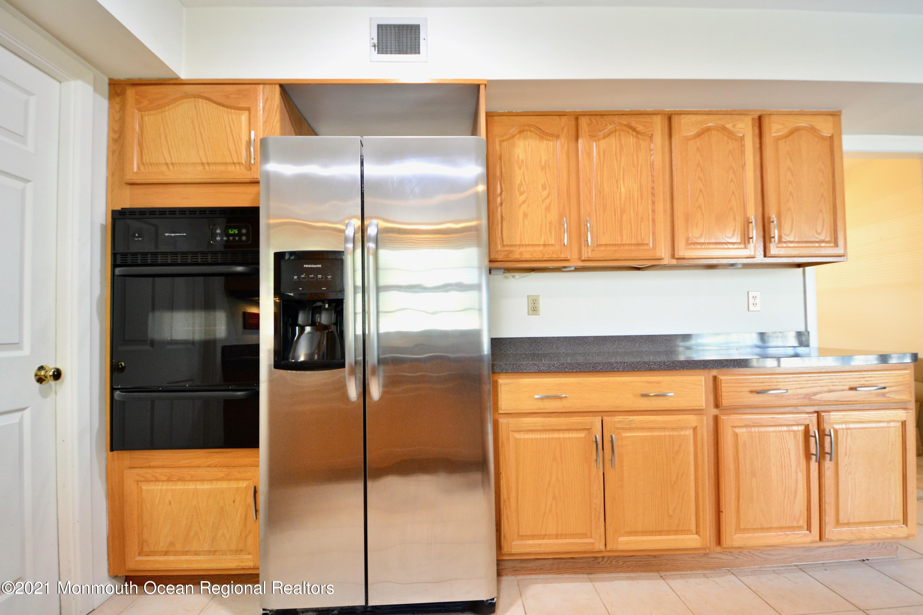 584 Lloyd Road Aberdeen, NJ 07747 - Photo 4 of 5 a kitchen with a refrigerator and cabinets