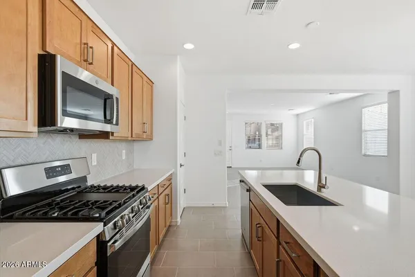 a kitchen with stainless steel appliances a sink a stove and microwave