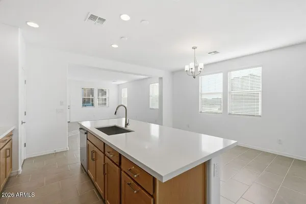 a kitchen that has a sink a window and chairs