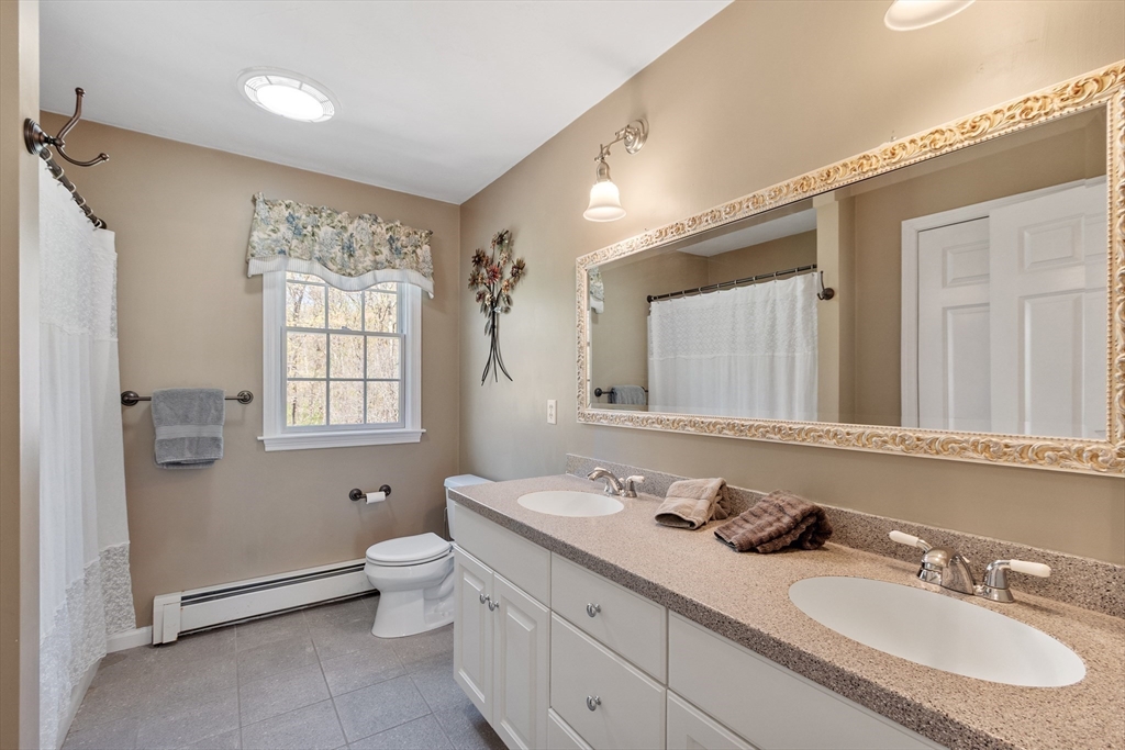 116 Coburn Road Berlin, MA 01503 - Photo 30 of 42 a bathroom with a double vanity sink toilet and a mirror