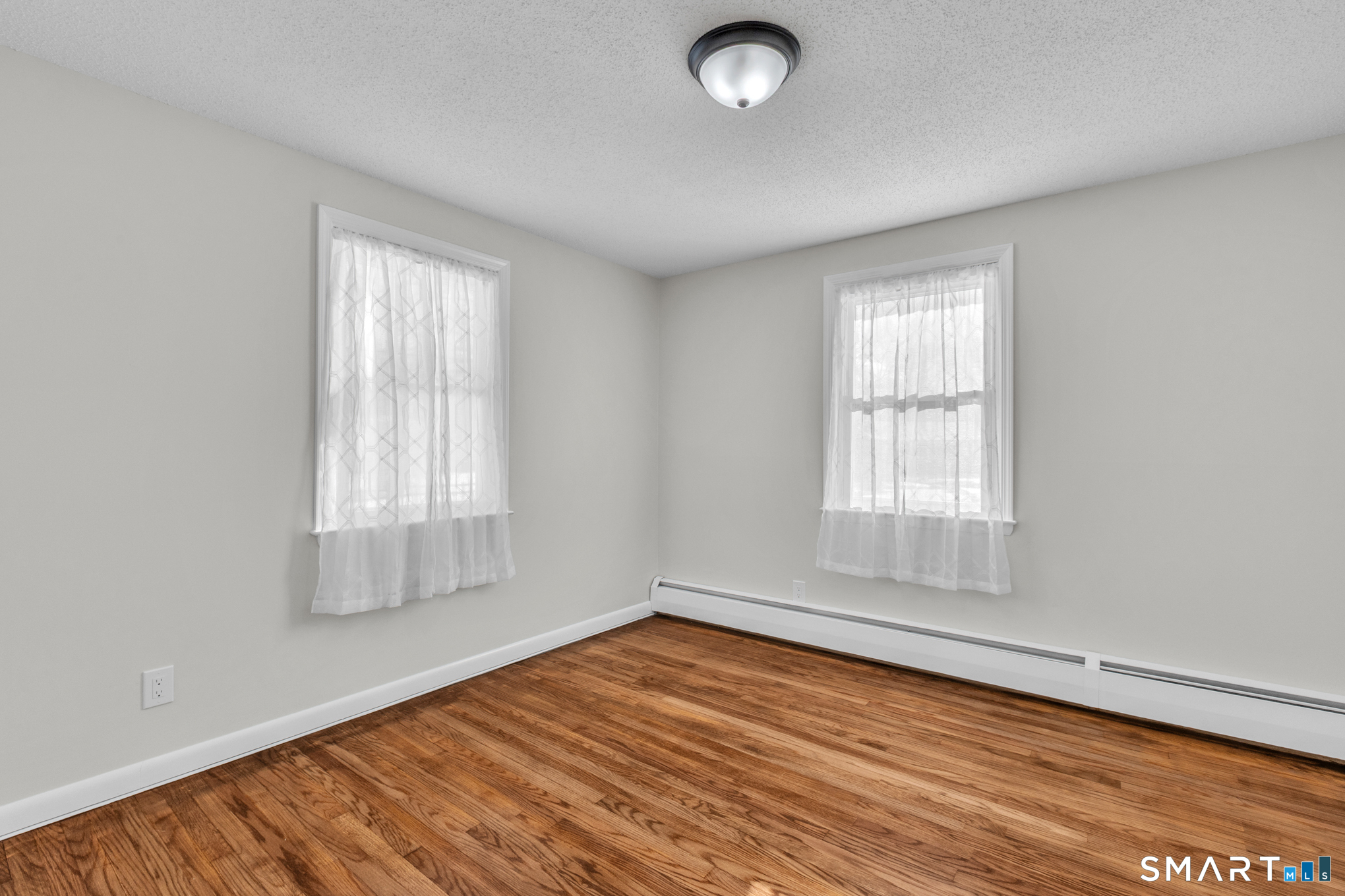 22 Mohawk Circle Newington, CT 06111 - Photo 27 of 39 an empty room with wooden floor and windows