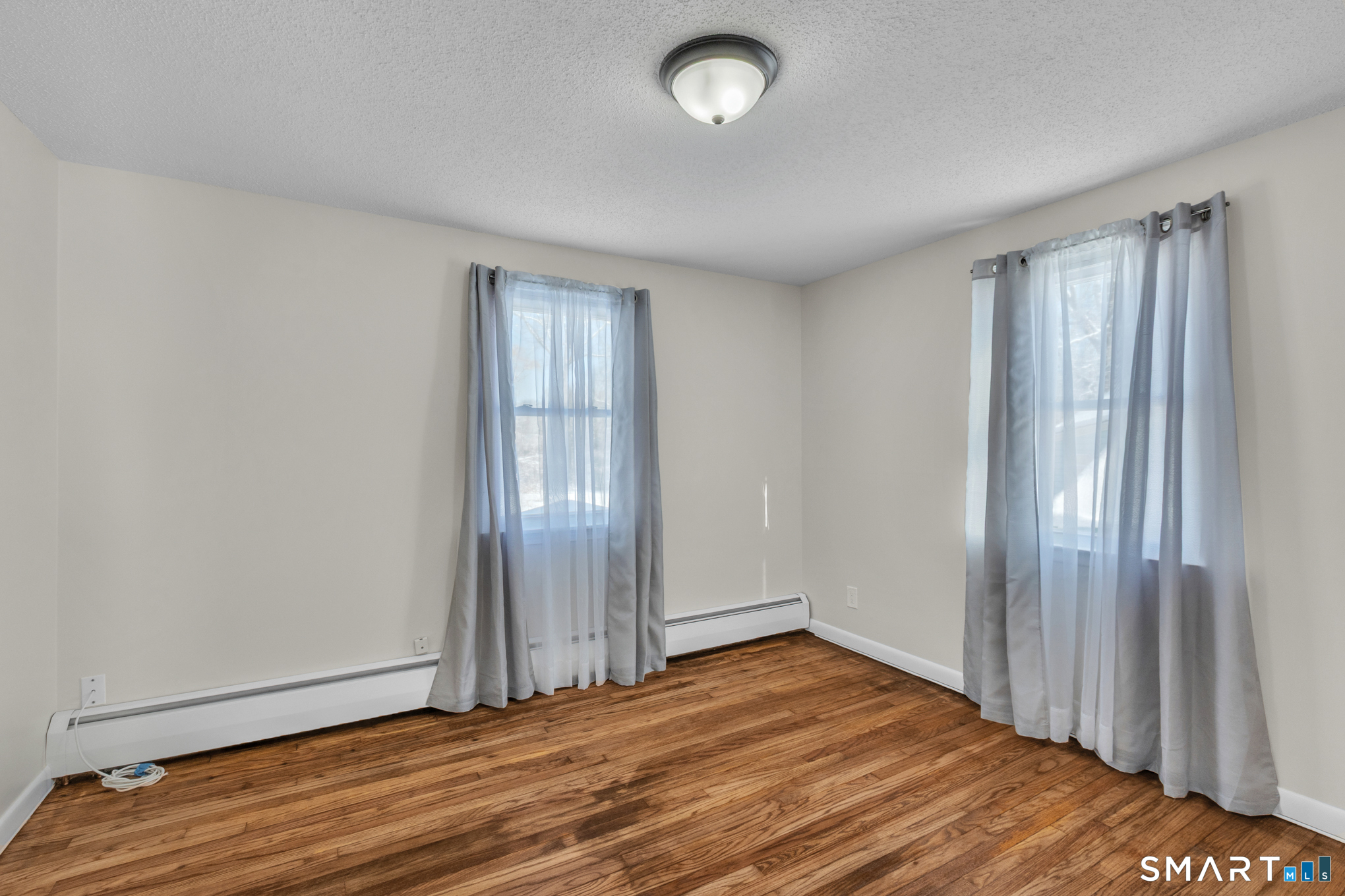 22 Mohawk Circle Newington, CT 06111 - Photo 32 of 39 an empty room with wooden floor and windows