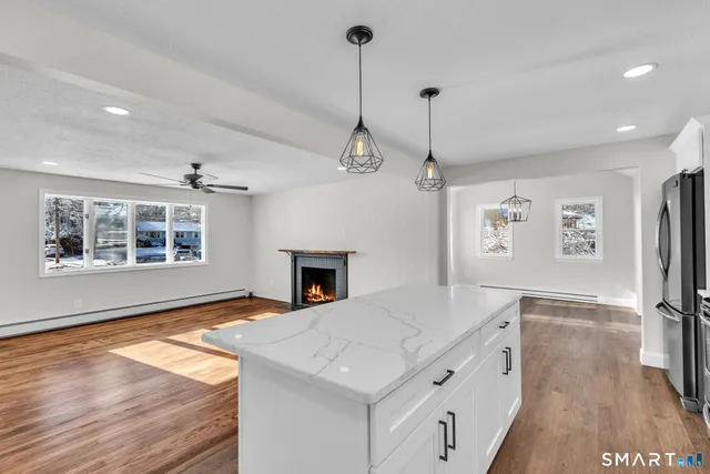 a kitchen with stainless steel appliances granite countertop a stove and a wooden floor