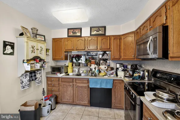 a kitchen with stainless steel appliances granite countertop a stove top oven a sink dishwasher and cabinets