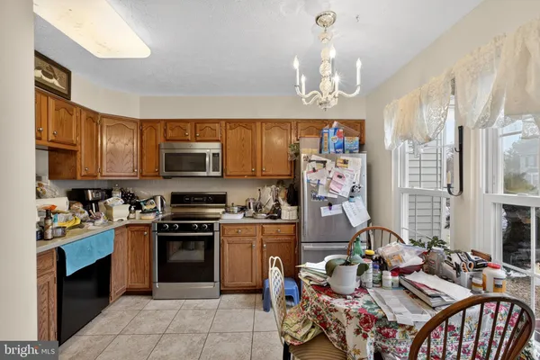 a kitchen with stainless steel appliances granite countertop a stove top oven a sink dishwasher and cabinets with wooden floor