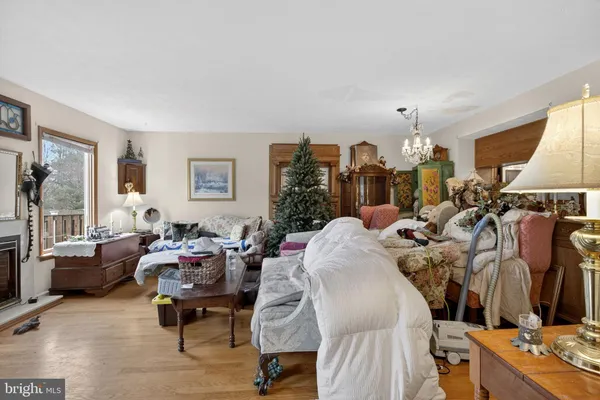 a living room with furniture kitchen view and a chandelier