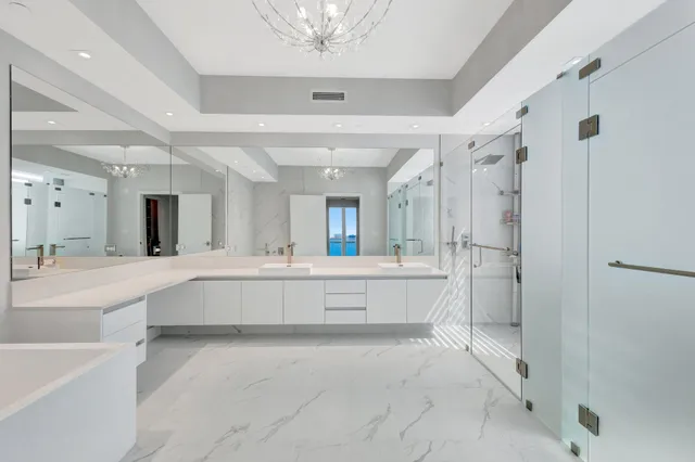 a large white bathroom with a large tub shower sink vanity granite and a mirror