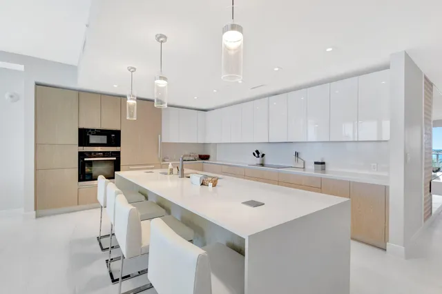 a kitchen with a sink a center island stainless steel appliances and cabinets