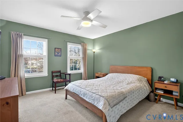a bedroom with a bed table chair and a window