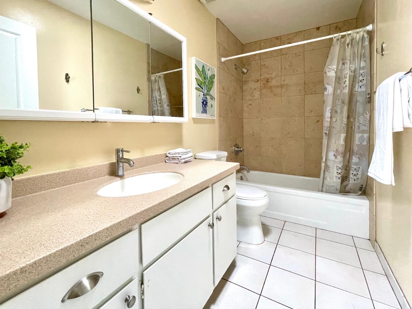 22801 Longdown Road Cupertino, CA 95014 - Photo 13 of 25 a bathroom with a granite countertop sink a toilet a mirror and shower