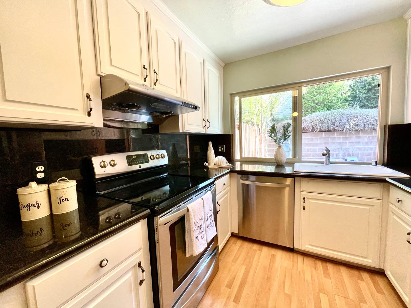 22801 Longdown Road Cupertino, CA 95014 - Photo 10 of 25 a kitchen with stainless steel appliances granite countertop a stove a sink and a microwave