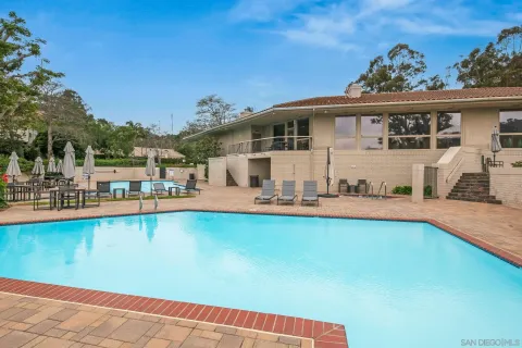 a view of a house with pool and chairs