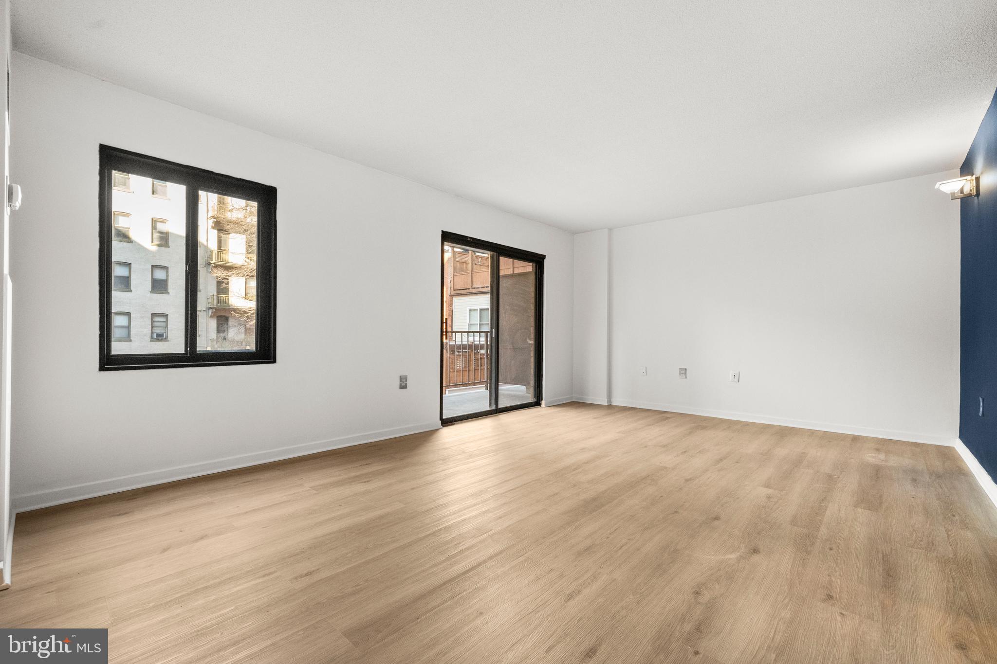 1718 P Street Northwest, Unit 316 Washington, DC 20036 - Photo 11 of 32 a view of an empty room with wooden floor and a window