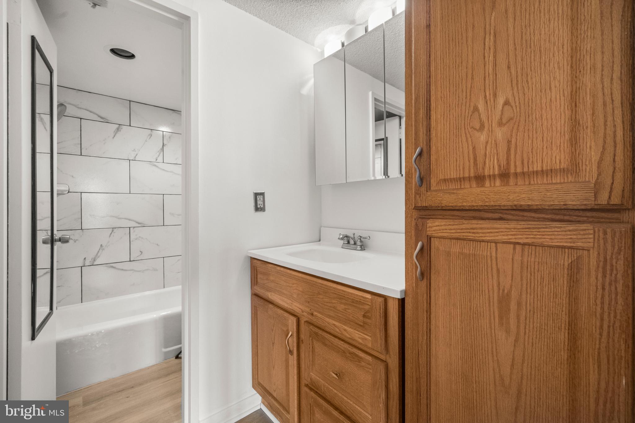1718 P Street Northwest, Unit 316 Washington, DC 20036 - Photo 14 of 32 a bathroom with a sink a mirror and a bathtub