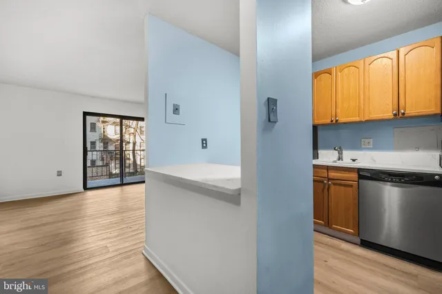 a kitchen with stainless steel appliances granite countertop a stove a sink and a refrigerator with wooden floors