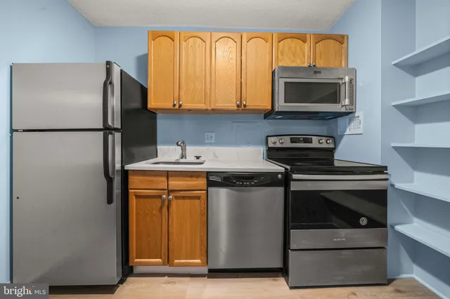 a kitchen with stainless steel appliances granite countertop a refrigerator stove and microwave