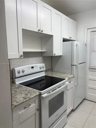 a kitchen with white cabinets and white appliances