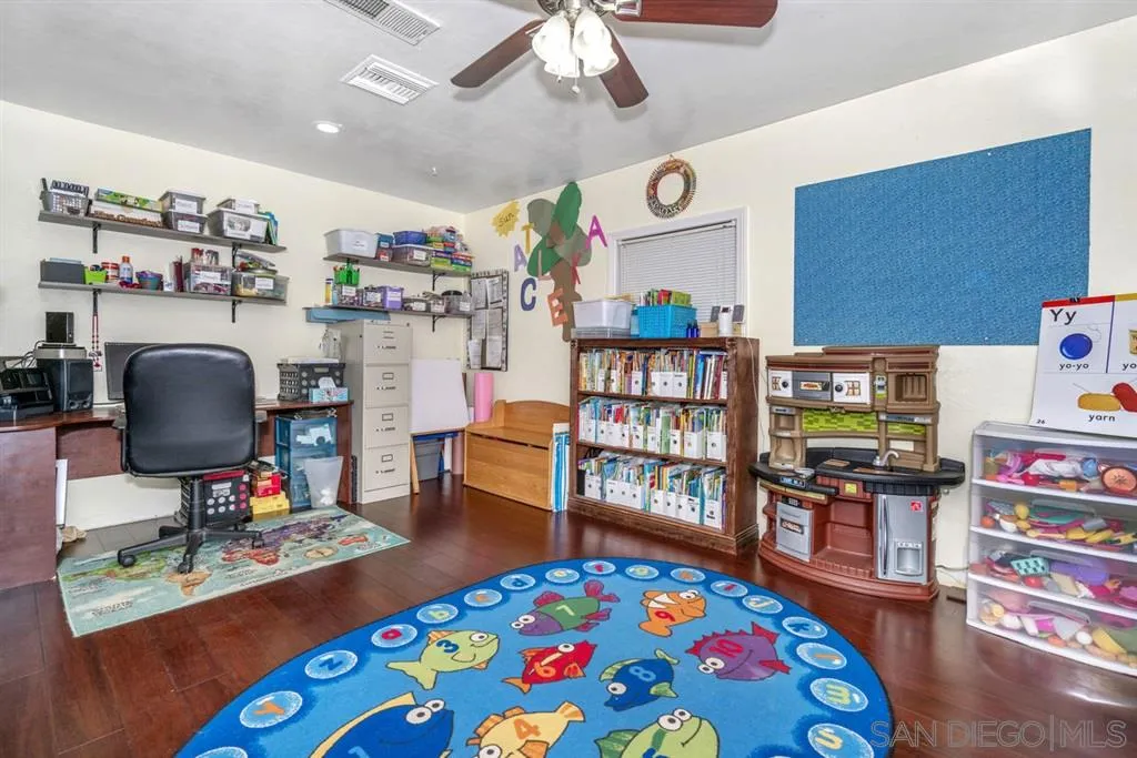 8311 Sunset Road Lakeside, CA 92040 - Photo 12 of 25 a bedroom with a bed and a bookshelf with wooden floor