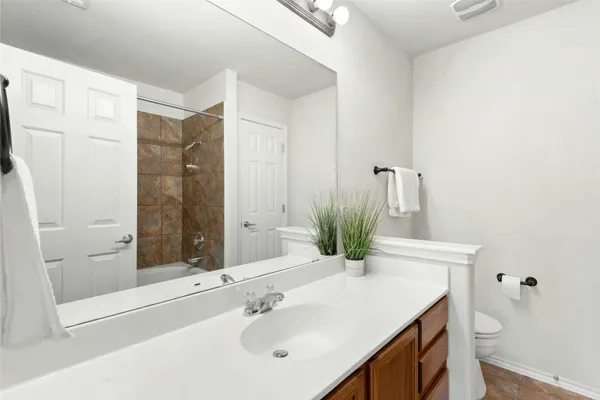 a bathroom with a sink vanity granite toilet and shower