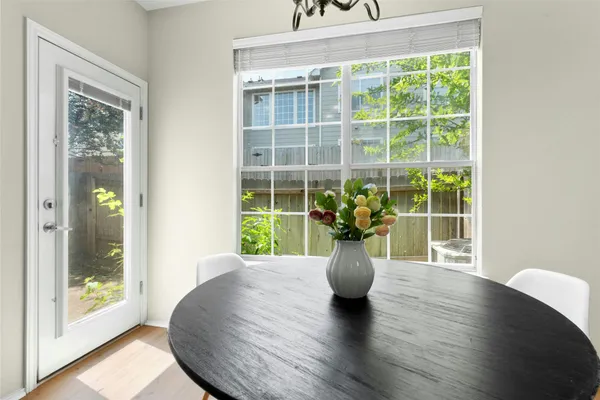 a view of a dining room with a large window wooden floor and front door
