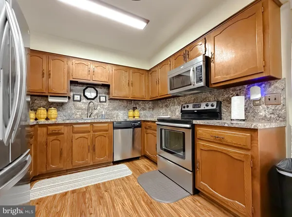 a kitchen with stainless steel appliances granite countertop a sink and cabinets