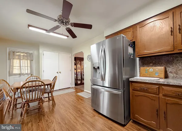 a kitchen with stainless steel appliances wooden floor dining table and chairs