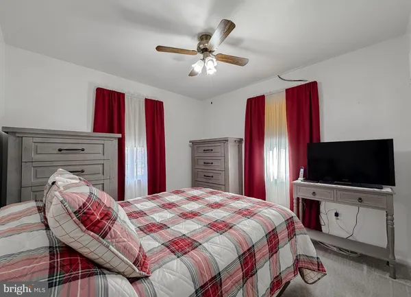 a bedroom with a bed and a flat tv screen on dresser