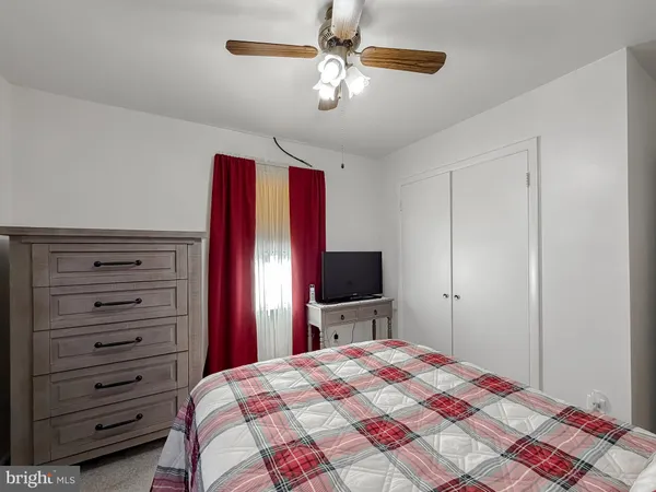 a spacious bedroom with a bed and a dresser