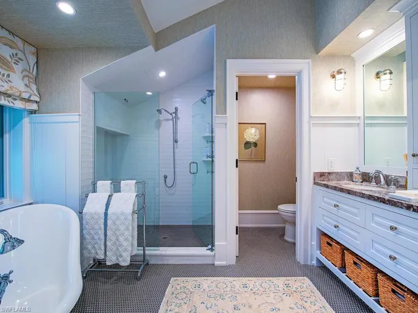 a spacious bedroom with a bed and a chandelier