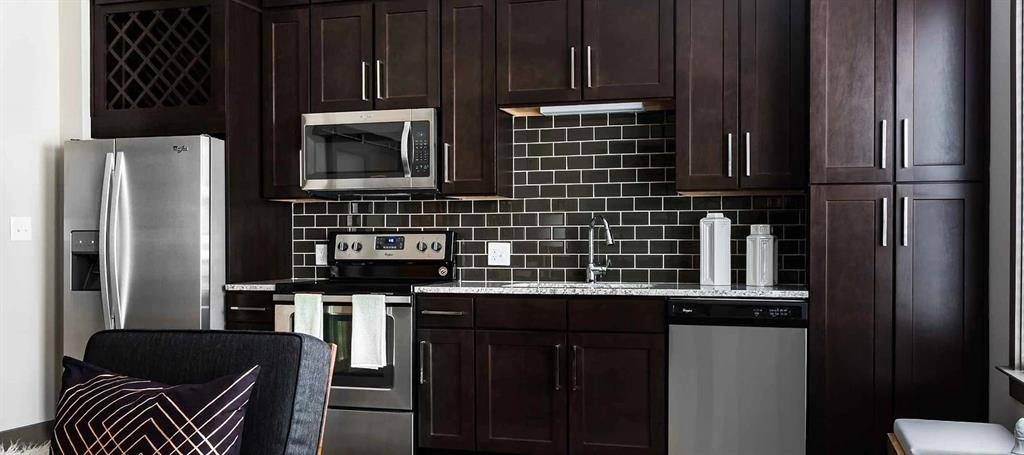 8110 Park Lane, Unit 901 Dallas, TX 75231 - Photo 5 of 18 a kitchen with stainless steel appliances a refrigerator and a stove top oven