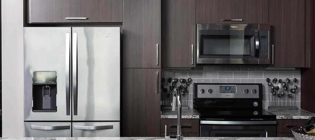 8110 Park Lane, Unit 901 Dallas, TX 75231 - Photo 6 of 18 a kitchen with stainless steel appliances granite countertop a stove and a microwave