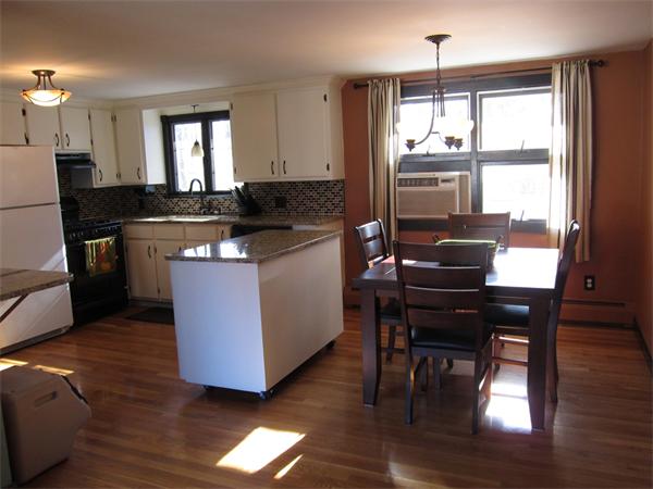 451 Lepes Road Somerset, MA 02726 - Photo 9 of 10 a kitchen with granite countertop wooden floors and wooden cabinets