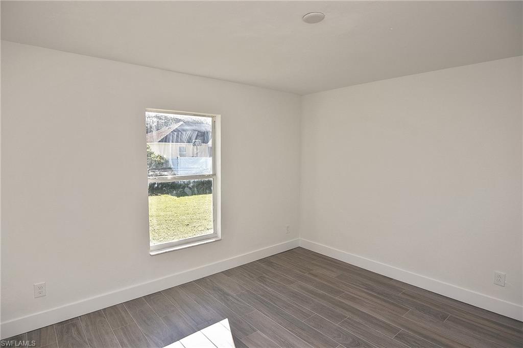 785 Homestead Road South Lehigh Acres, FL 33974 - Photo 40 of 49 an empty room with wooden floor and windows