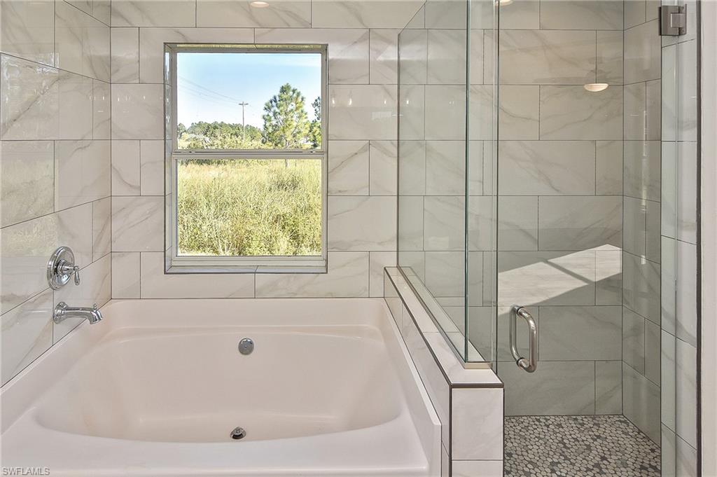 785 Homestead Road South Lehigh Acres, FL 33974 - Photo 5 of 49 a white bath tub sitting next to a shower