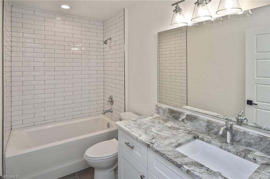 785 Homestead Road South Lehigh Acres, FL 33974 - Photo 8 of 49 a bathroom with a granite countertop sink a toilet and bathtub
