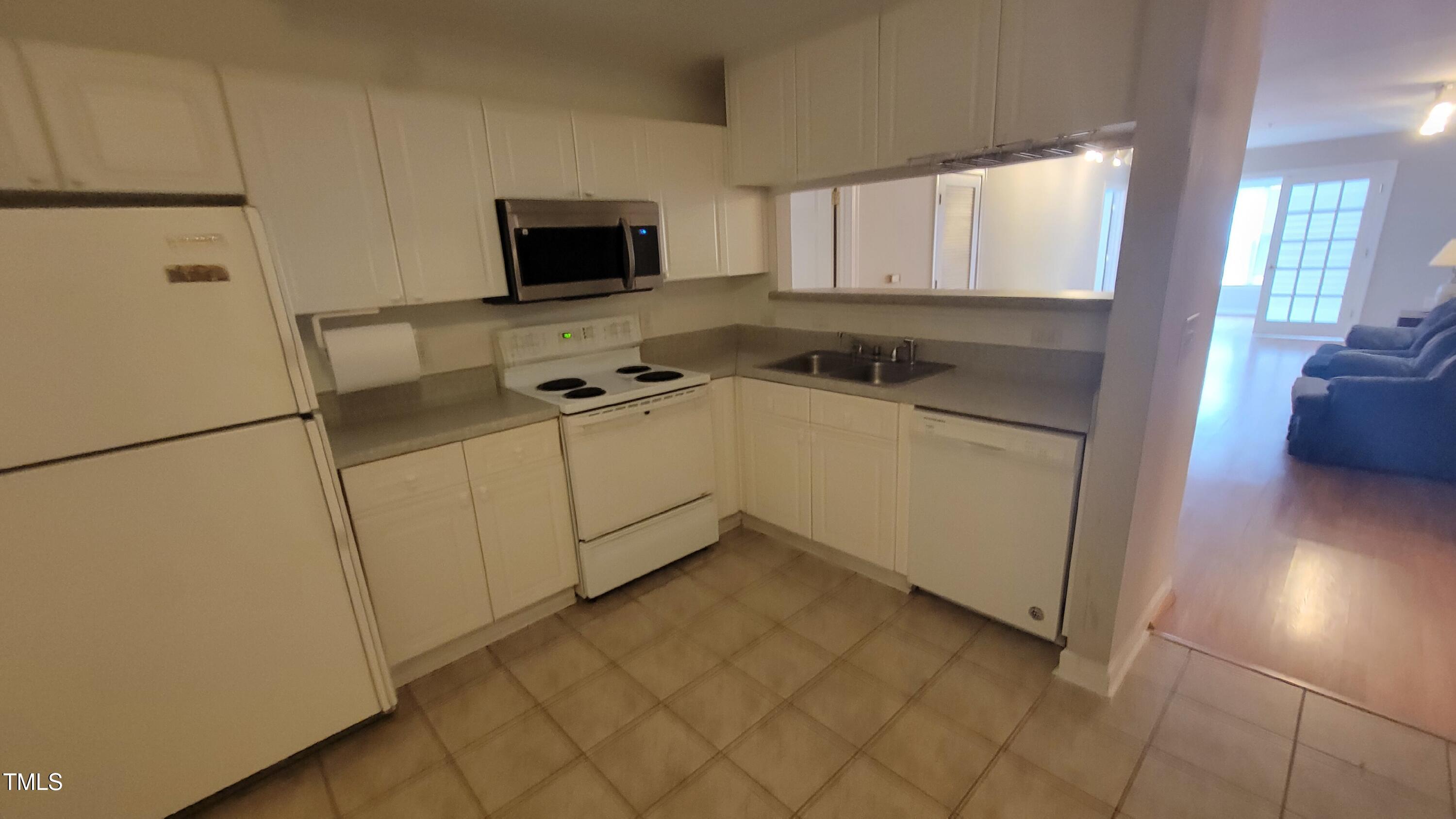 929 Morreene Road, Unit A13 Durham, NC 27705 - Photo 2 of 18 a kitchen with stainless steel appliances a refrigerator sink and cabinets