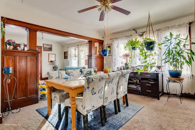 a view of a dining room and livingroom with furniture wooden floor a chandelier