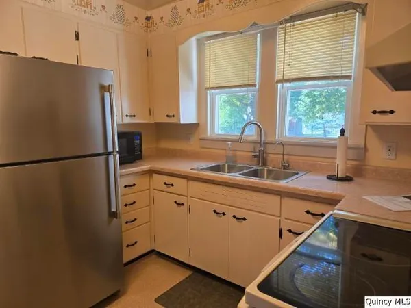 a kitchen with stainless steel appliances a refrigerator sink and wooden cabinets