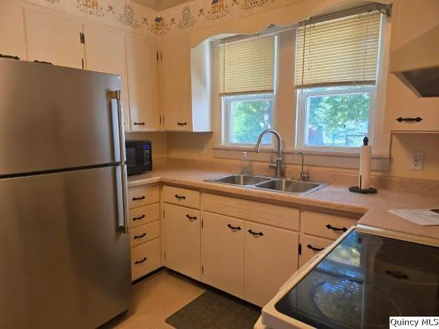 a kitchen with stainless steel appliances a refrigerator sink and wooden cabinets