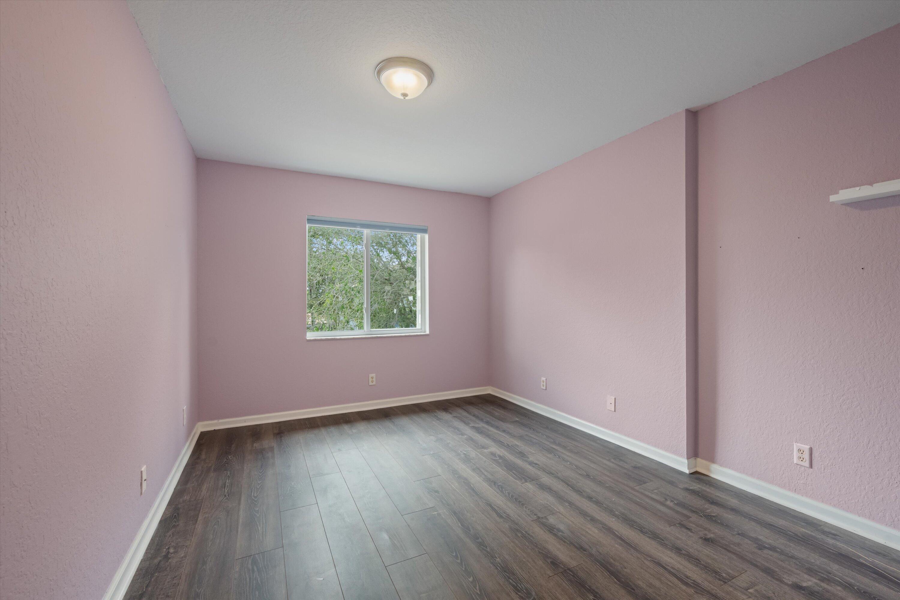 1222 Rose Gate Boulevard Riviera Beach, FL 33404 - Photo 20 of 29 an empty room with wooden floor and windows