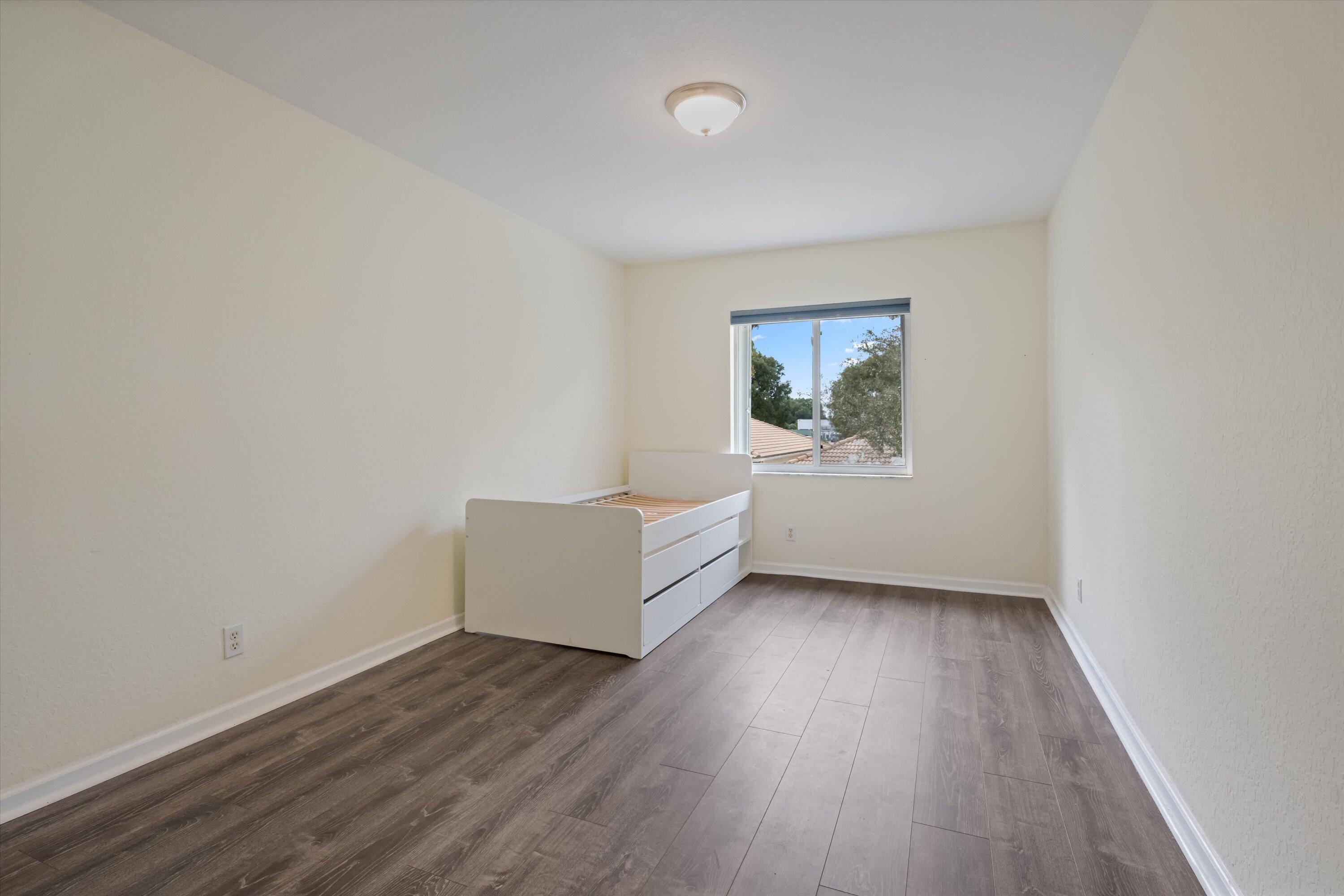 1222 Rose Gate Boulevard Riviera Beach, FL 33404 - Photo 23 of 29 an empty room with wooden floor and window