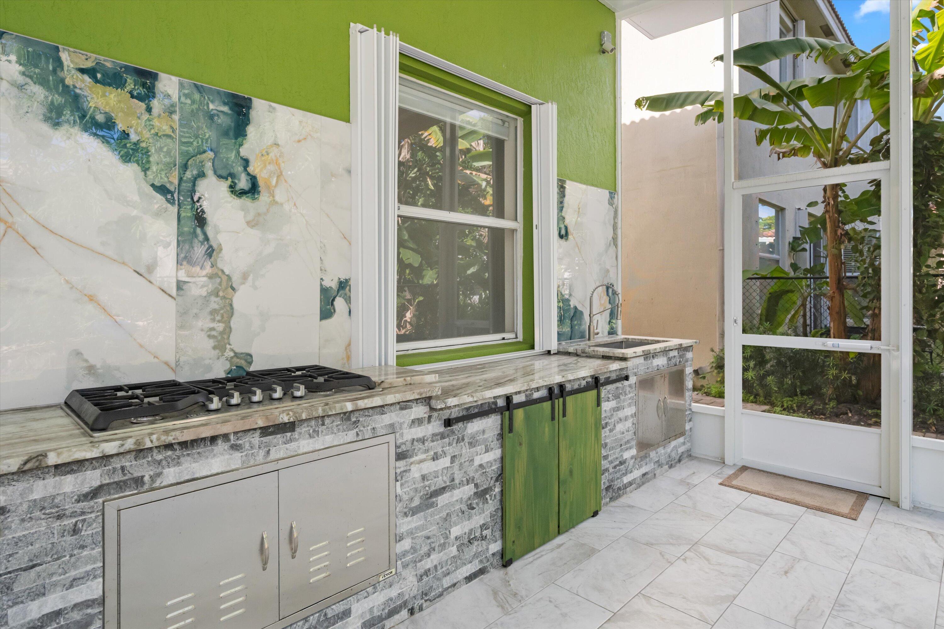 1222 Rose Gate Boulevard Riviera Beach, FL 33404 - Photo 25 of 29 a kitchen with a stove a sink and a window