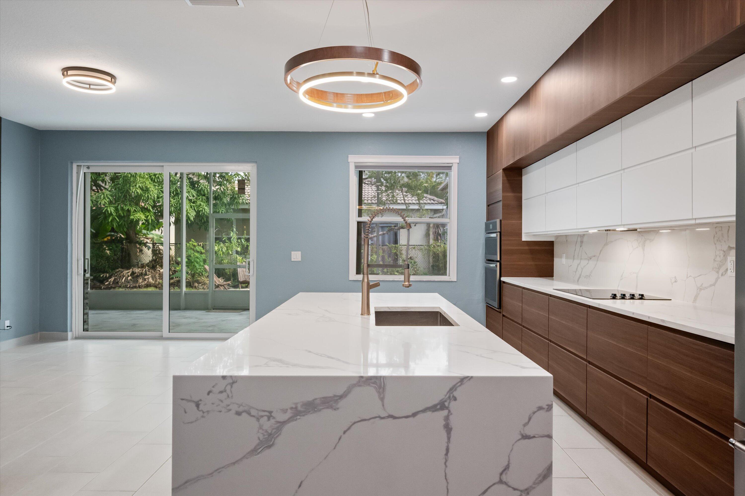 1222 Rose Gate Boulevard Riviera Beach, FL 33404 - Photo 9 of 29 a kitchen with stainless steel appliances a sink a stove and a wooden floors
