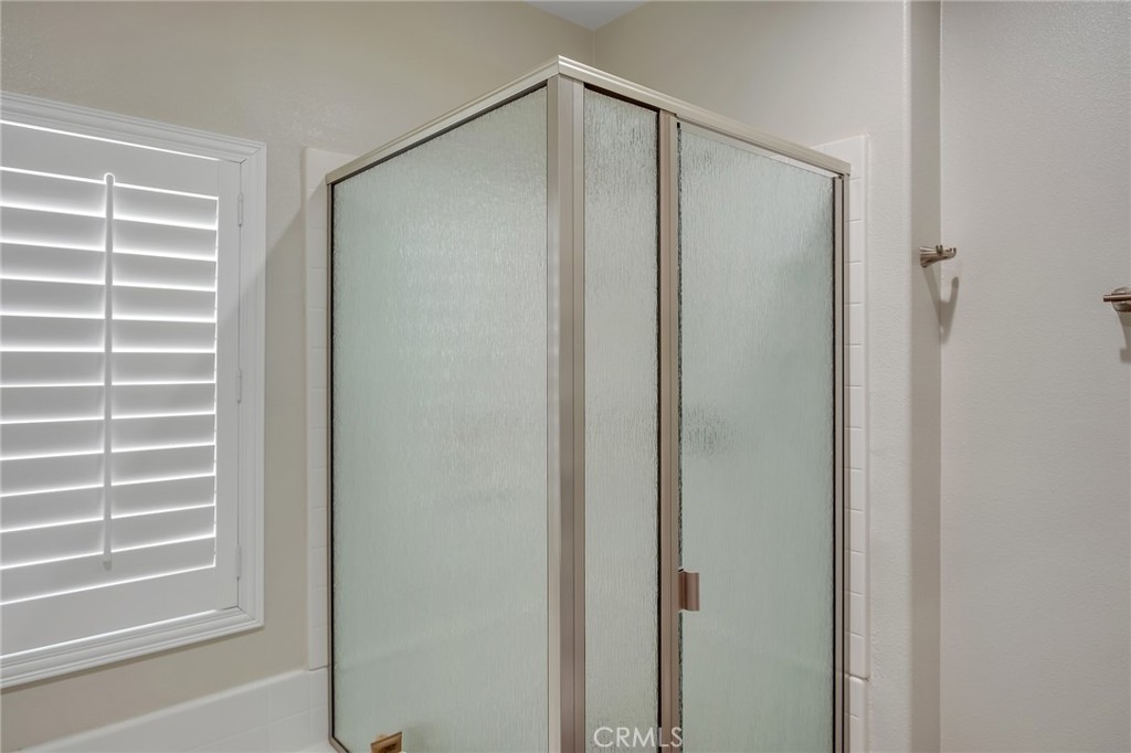 13178 Setancket Road Apple Valley, CA 92308 - Photo 19 of 24 a bathroom with a glass shower door and a window