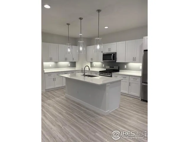 a kitchen with a sink cabinets and wooden floor