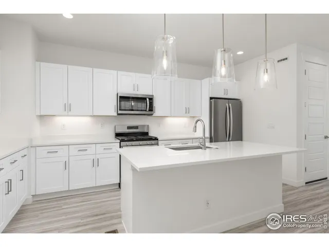 a kitchen with kitchen island a sink stainless steel appliances and cabinets