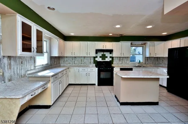a kitchen with stainless steel appliances granite countertop a sink counter space cabinets and a large window